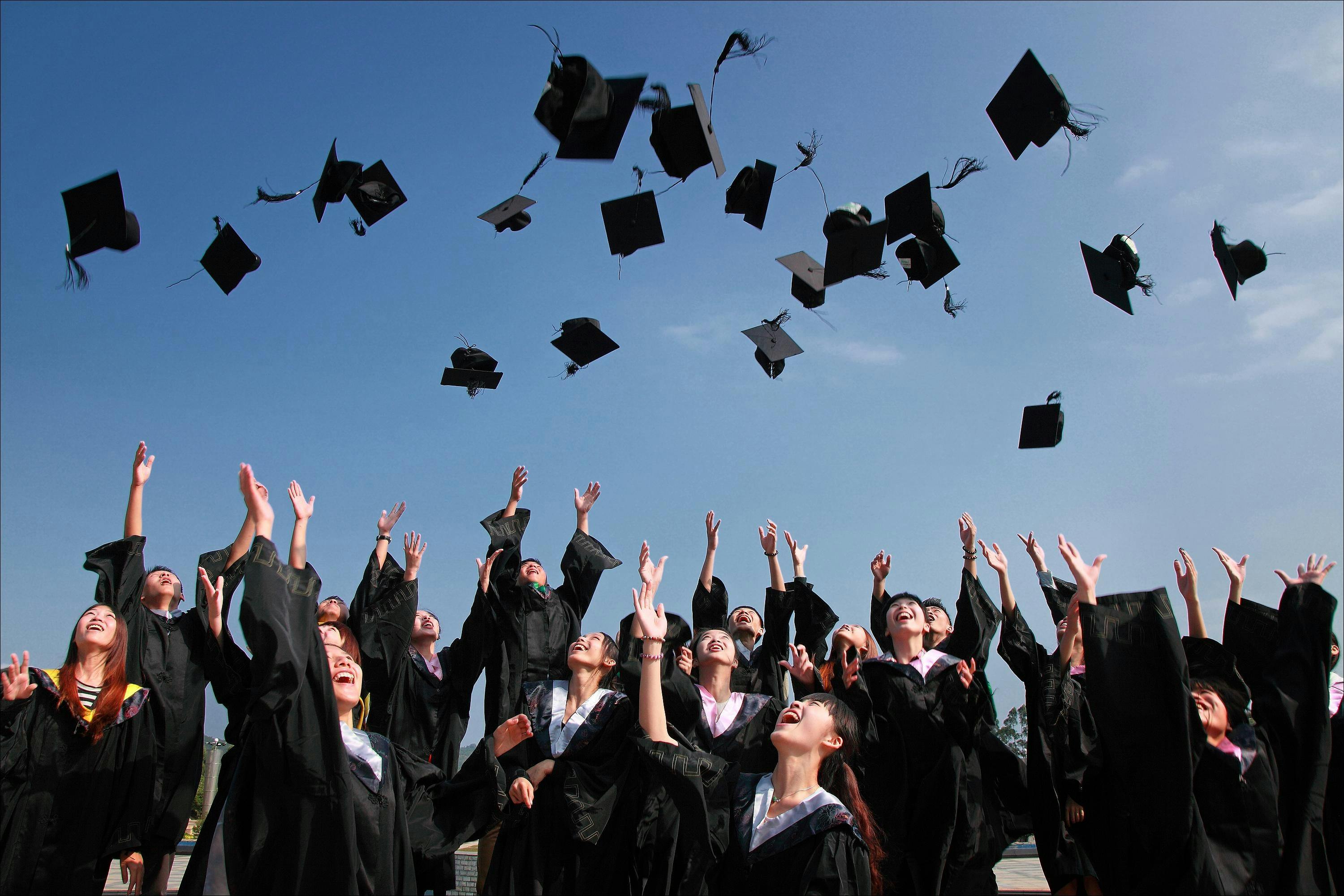 Graduates throwing hats into air